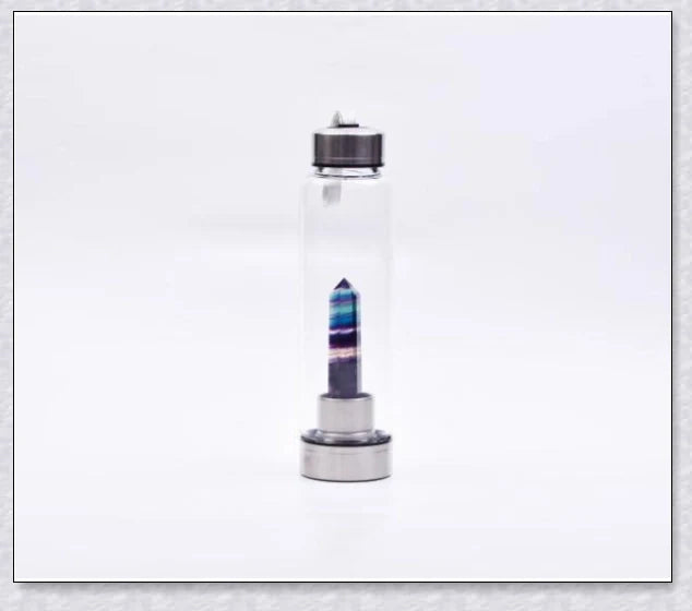 A natural crystal water bottle made of borosilicate glass, featuring a variety of healing crystals inside to enhance your hydration experience.