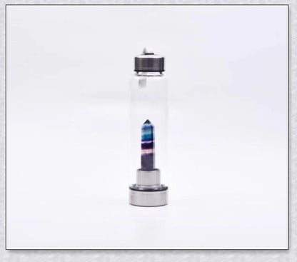 A natural crystal water bottle made of borosilicate glass, featuring a variety of healing crystals inside to enhance your hydration experience.