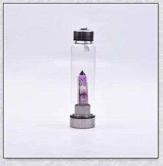 A natural crystal water bottle made of borosilicate glass, featuring a variety of healing crystals inside to enhance your hydration experience.