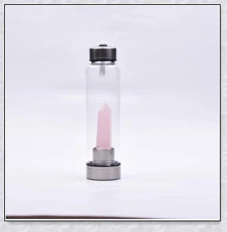 A natural crystal water bottle made of borosilicate glass, featuring a variety of healing crystals inside to enhance your hydration experience.
