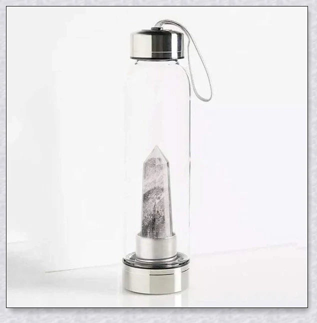 A natural crystal water bottle made of borosilicate glass, featuring a variety of healing crystals inside to enhance your hydration experience.