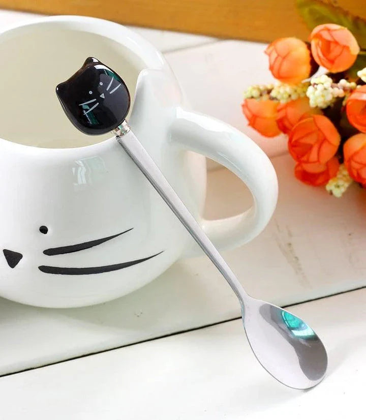 Cartoon cat-shaped ceramic coffee mug with matching stainless steel spoon, a practical and whimsical addition to any morning routine.