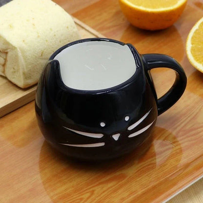 Cartoon cat-shaped ceramic coffee mug with matching stainless steel spoon, a practical and whimsical addition to any morning routine.