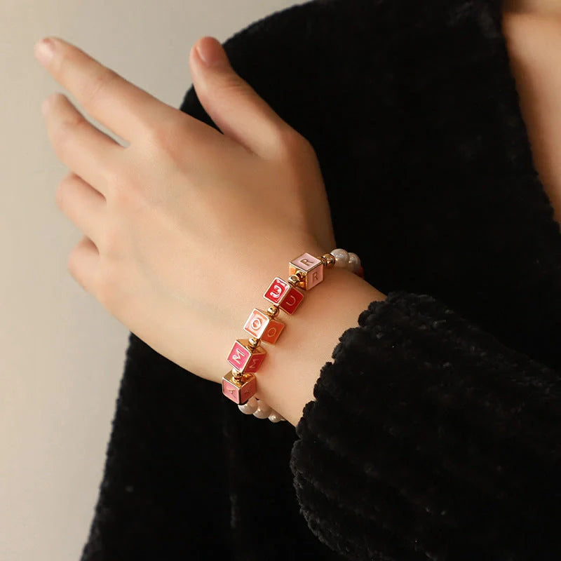 Elegant necklace and bracelet set with delicate beads and English letter charms, crafted with premium alloy materials