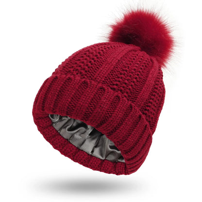 Stylish knit beanie with satin lining and faux fur pom-pom for women, available in multiple color options