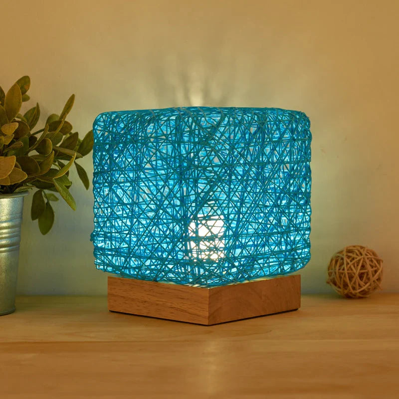 Handcrafted dimmable LED desk lamp made from sustainable rattan and wood, providing adjustable lighting and USB charging for home or office use.