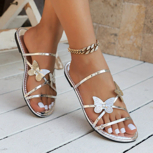 Women's butterfly cross-strap sandals in black, silver, gold, and champagne colours