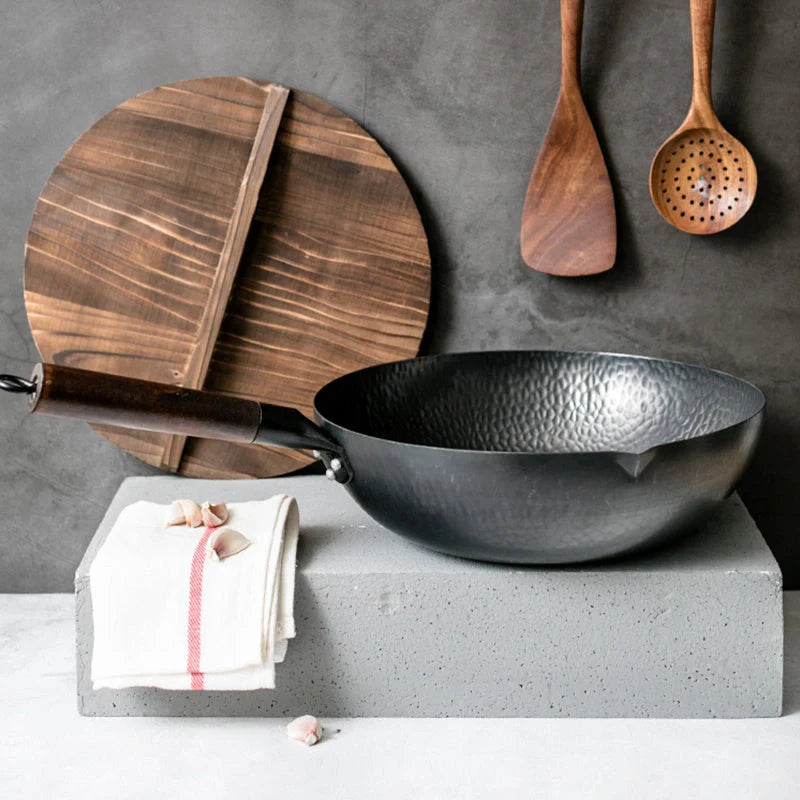Traditional handmade iron wok with wooden handle and lid
