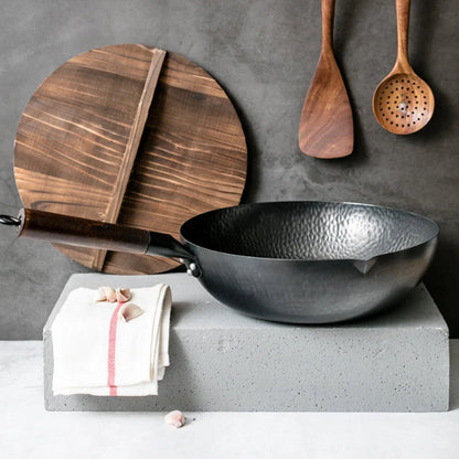 Traditional handmade iron wok with wooden handle and lid