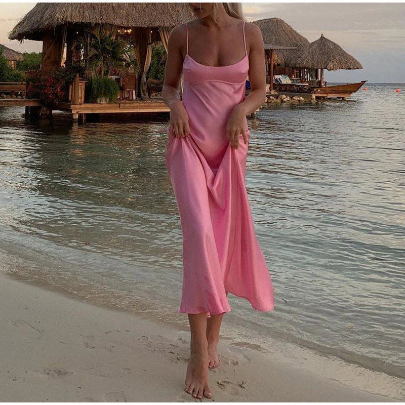 A sleek and elegant satin slip dress in a stunning pink color with a backless design and full-length silhouette.