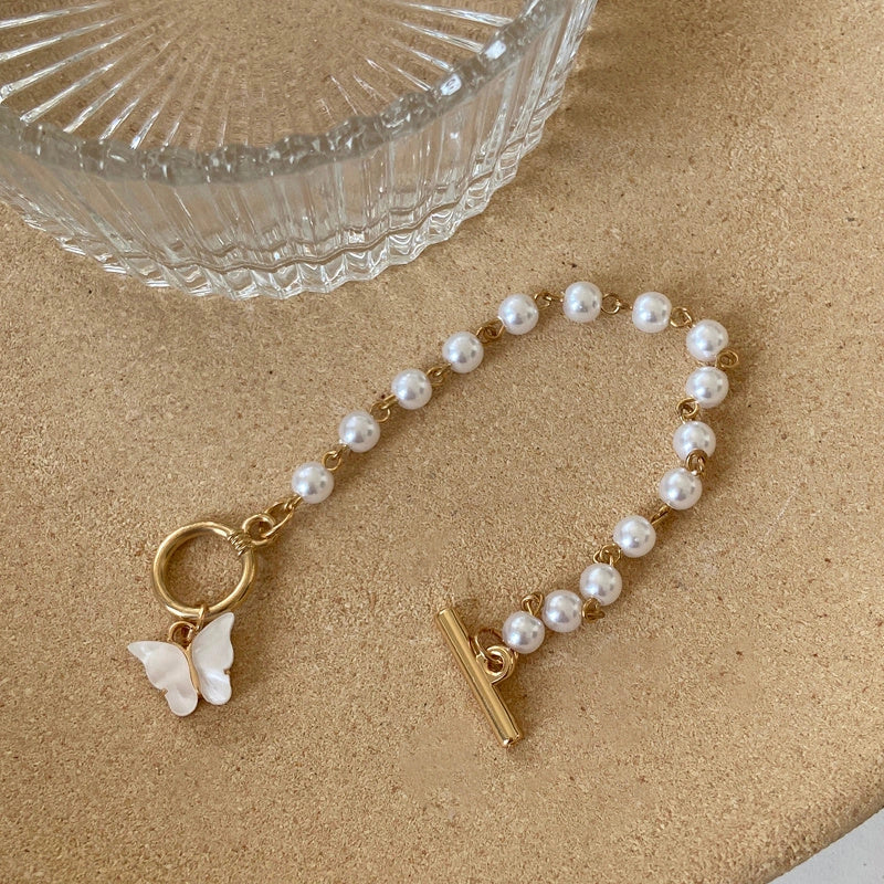 Gold charm chain bracelet with pearl and butterfly design for women