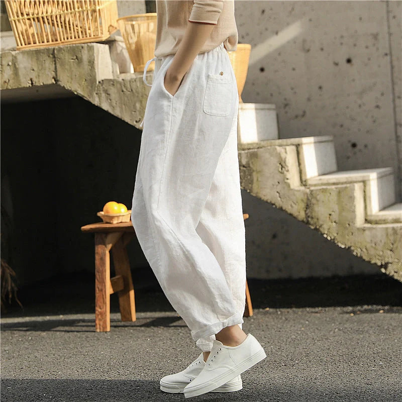Elegant white linen trousers with a relaxed, artistic silhouette and cropped length