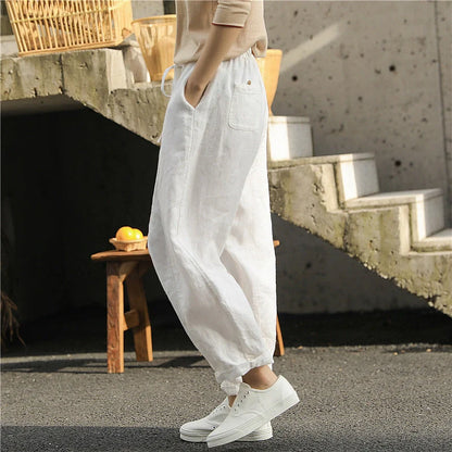 Elegant white linen trousers with a relaxed, artistic silhouette and cropped length