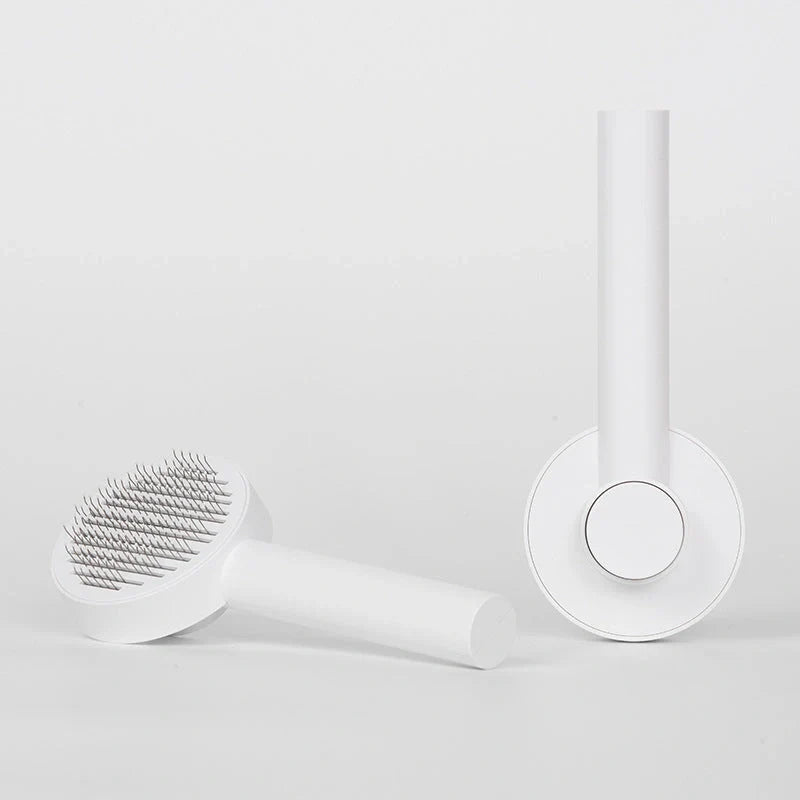 Self-cleaning pet grooming comb with stainless steel needles in blue, pink, and white