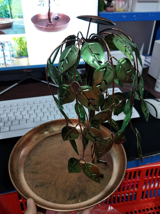 Aged copper Tree of Life electric fountain with cascading waterfall in a lush garden setting