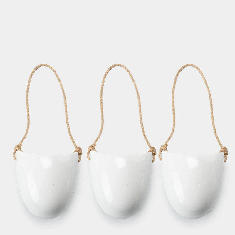 Wall-mounted ceramic flower pot in matte white with hemp rope for balcony gardening