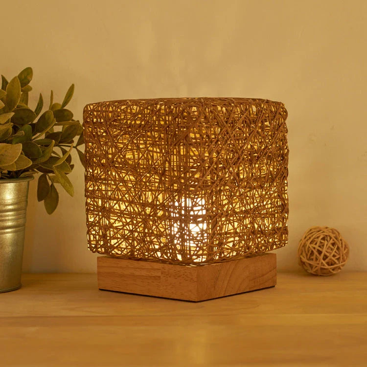 Handcrafted dimmable LED desk lamp made from sustainable rattan and wood, providing adjustable lighting and USB charging for home or office use.