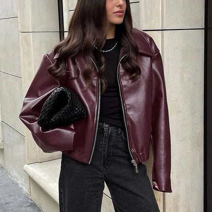 Fashionable faux leather jacket in burgundy and black colors, featuring a zipper closure and long sleeves for casual, versatile wear