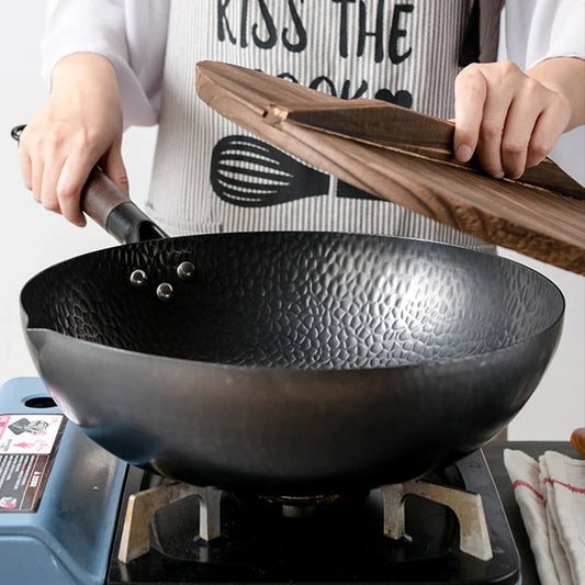 Traditional handmade iron wok with wooden handle and lid