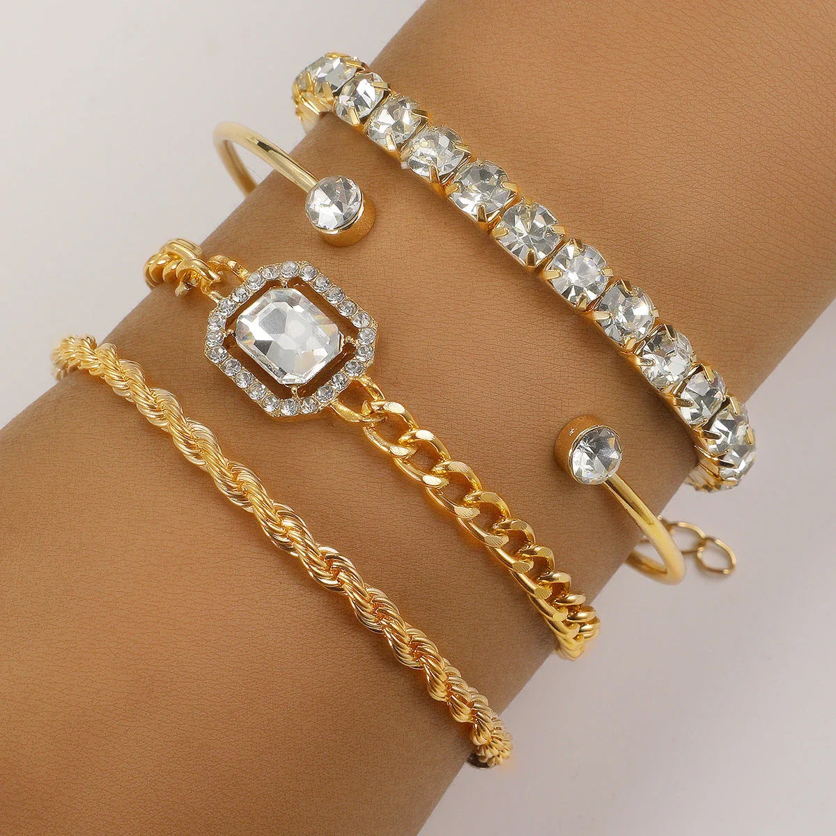 A set of four elegant crystal bracelets with vintage-inspired twisted cuff chains and sparkling rhinestones, perfect for adding a touch of luxury to any outfit.