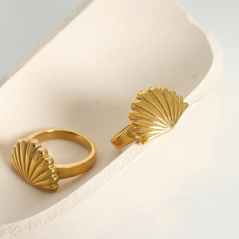 Ocean Style Scallop Ring in titanium steel and gold finishes, showcasing geometric design inspired by the sea.