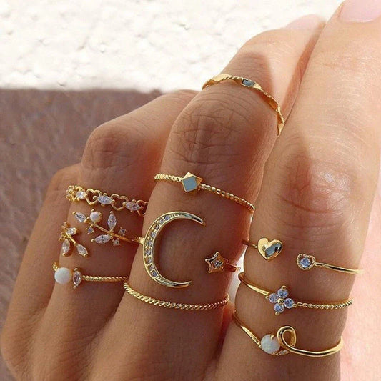 A set of 10 adjustable gold-plated rings with celestial-inspired designs including moons, stars, and pearls