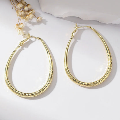 Golden egg-shaped hypoallergenic copper earrings with spring fastener