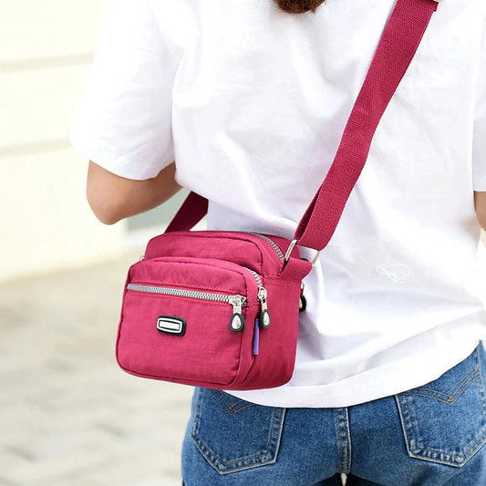 Small square messenger bag in water-repellent nylon with multi-compartment design