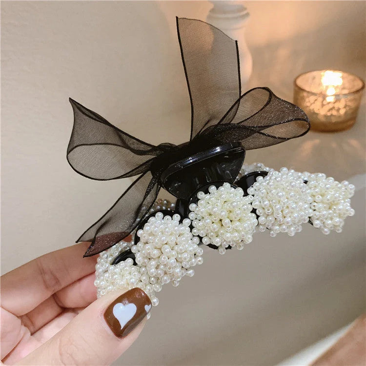 Korean pearl bow hair clip in black, alloy construction for durability and style.