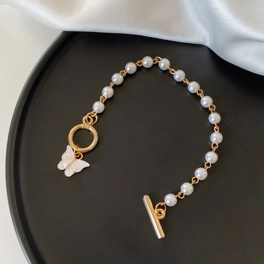 Gold charm chain bracelet with pearl and butterfly design for women