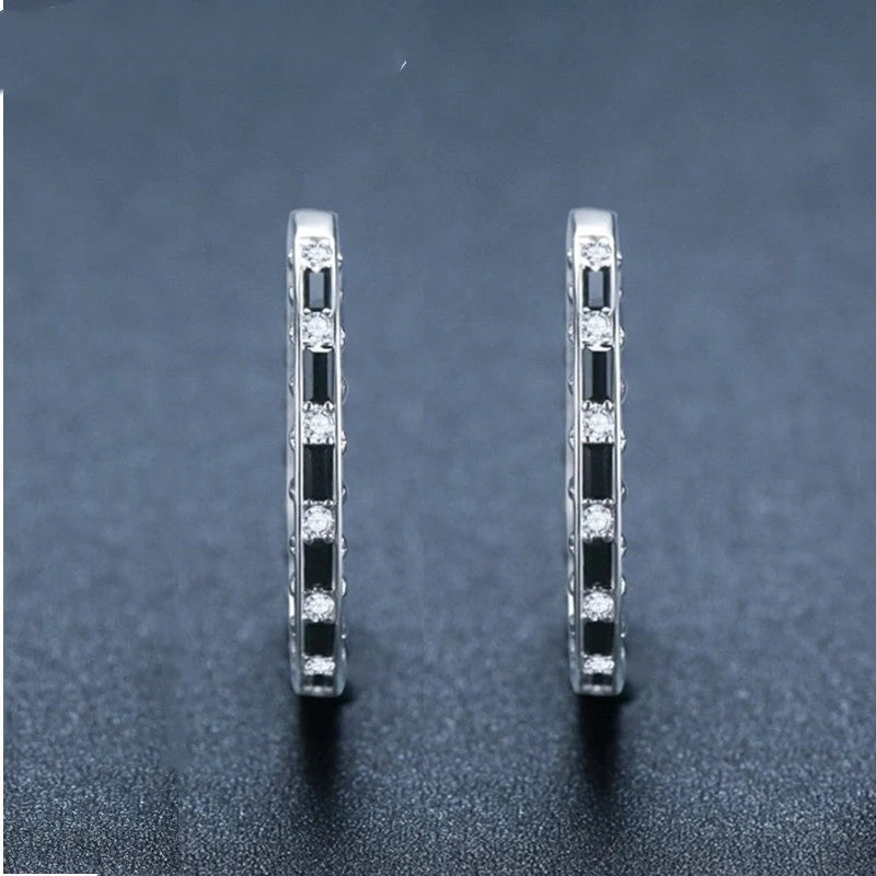 A pair of elegant black zircon earrings with a round, geometric design made of premium copper
