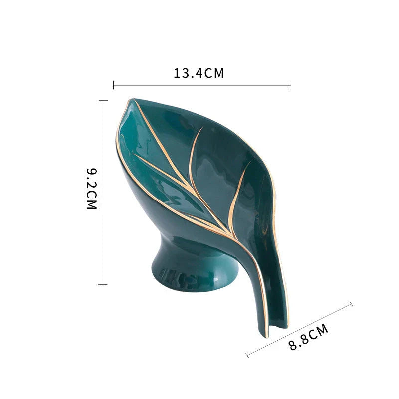 Elegant ceramic soap dish with leaf-shaped design, suction cup base, and drainage holes for bathroom storage and decor