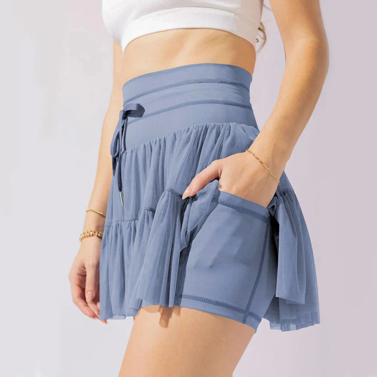 A stylish high-waist lace-up sports skirt with built-in safety shorts in a variety of vibrant colors.