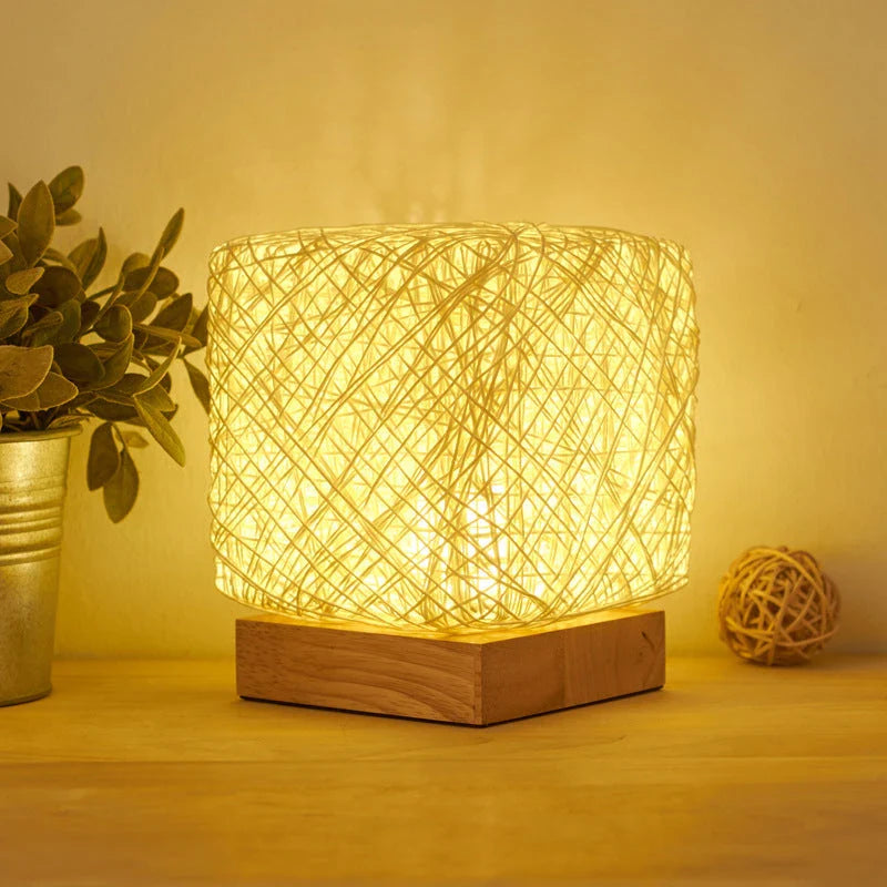 Handcrafted dimmable LED desk lamp made from sustainable rattan and wood, providing adjustable lighting and USB charging for home or office use.
