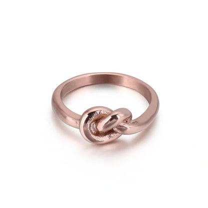 Sleek titanium steel geometric love knot ring in golden and rose gold colours, showcasing a modern and sophisticated design
