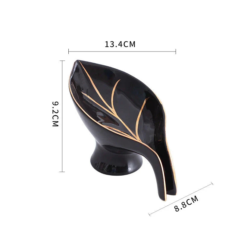Elegant ceramic soap dish with leaf-shaped design, suction cup base, and drainage holes for bathroom storage and decor