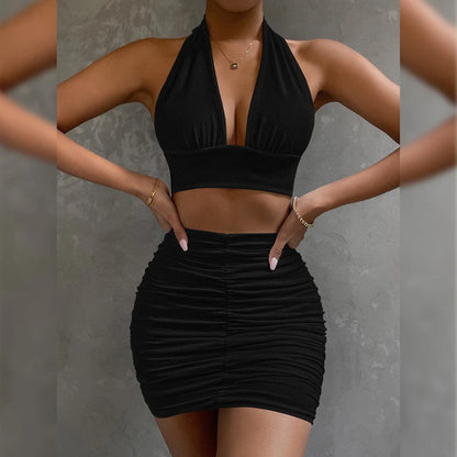 A stylish two-piece dress set featuring a halter-style lace-up top and a pleated hip-covering skirt, available in white, black, and pea green colors.
