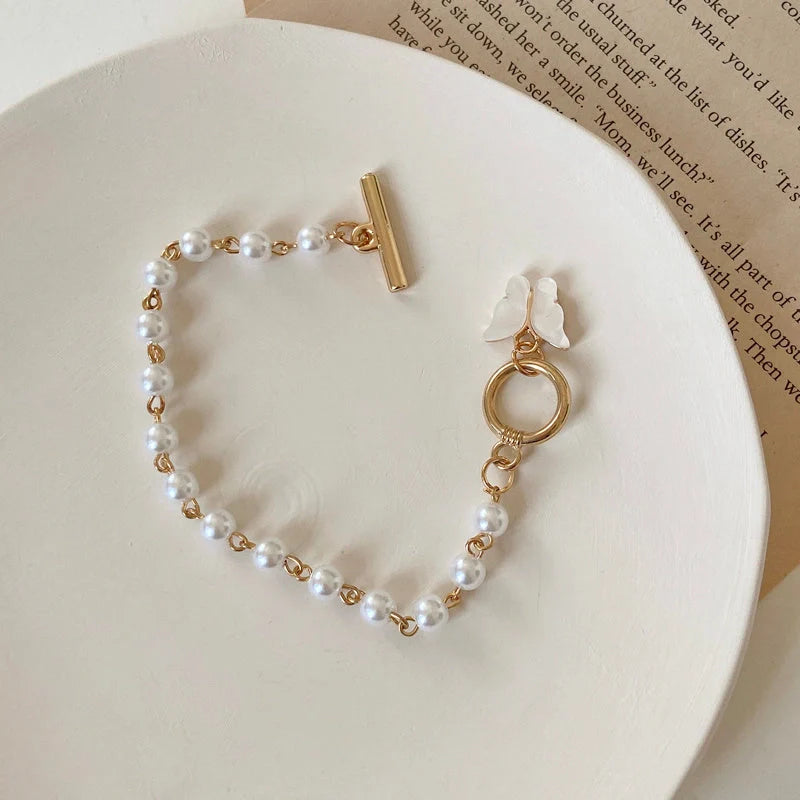 Gold charm chain bracelet with pearl and butterfly design for women