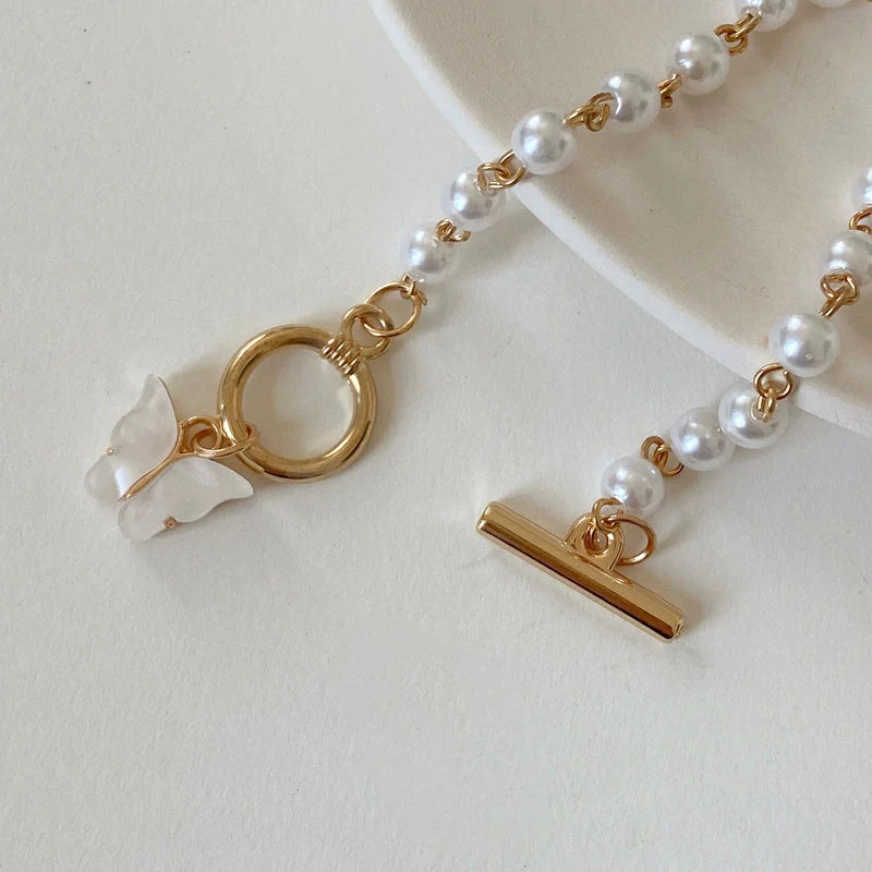 Gold charm chain bracelet with pearl and butterfly design for women