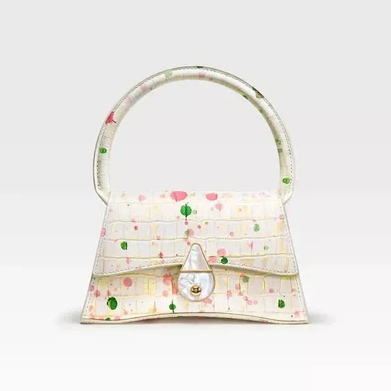 A stylish half-moon shaped genuine leather handbag with a decorative lock, showcasing premium British craftsmanship and timeless elegance.