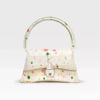 A stylish half-moon shaped genuine leather handbag with a decorative lock, showcasing premium British craftsmanship and timeless elegance.