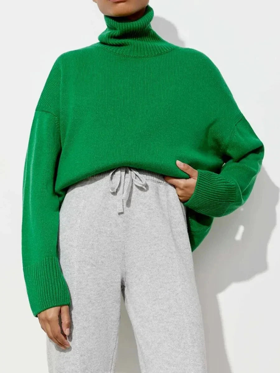 Cosy oversized knitted pullover in blue, featuring a classic turtleneck collar and drop-shoulder silhouette for maximum comfort and style.