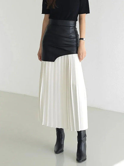 A stylish long pleated skirt featuring a sophisticated leather patchwork design and a flattering A-line silhouette
