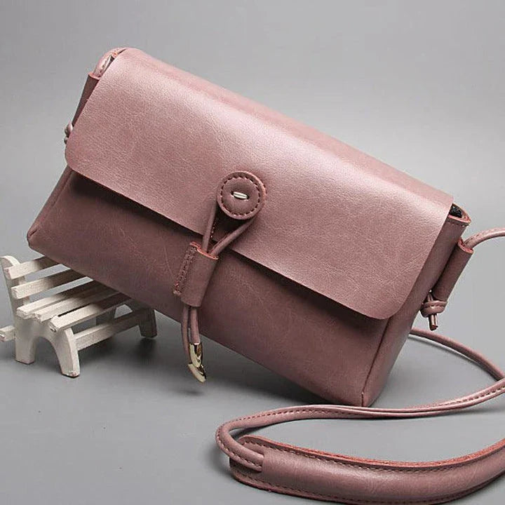 Premium leather crossbody bag in a sleek, horizontal square design with subtle car stitching details