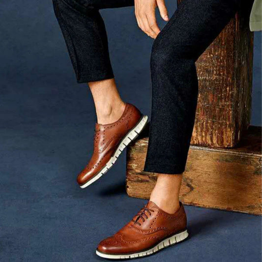 A pair of premium leather business shoes with a thick rubber sole and a stylish leather toe cap, available in brown and black colours.