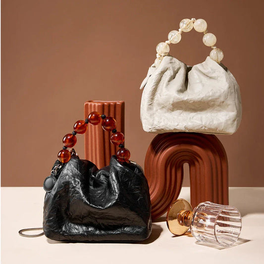 Premium leather crossbody bag with intricate beadwork, featuring a classic saddle shape and adjustable shoulder straps for versatile and secure everyday use.