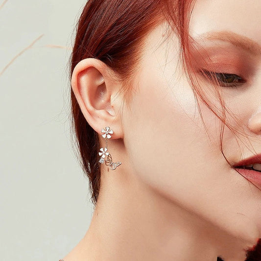 Pair of silver earrings featuring a butterfly-shaped floral design with sparkling white crystals, inspired by the enchanting Forest Series