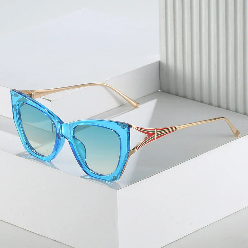 Refined cat eye sunglasses with blue gradient lenses and sleek metal frames, offering timeless British style and UV400 protection.