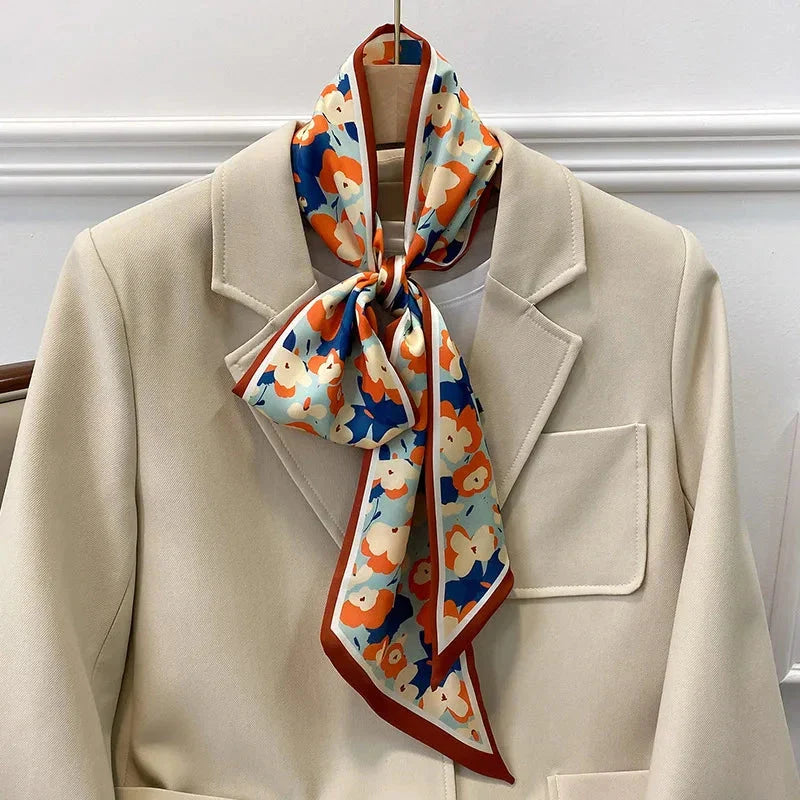 A vibrant floral-patterned silk-feel long scarf that can be worn as a neck accessory, hair tie, or wrist adornment for all occasions.