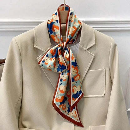 A vibrant floral-patterned silk-feel long scarf that can be worn as a neck accessory, hair tie, or wrist adornment for all occasions.